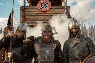 Un grupo de hombres vestidos con armaduras medievales de pie uno al lado del otro