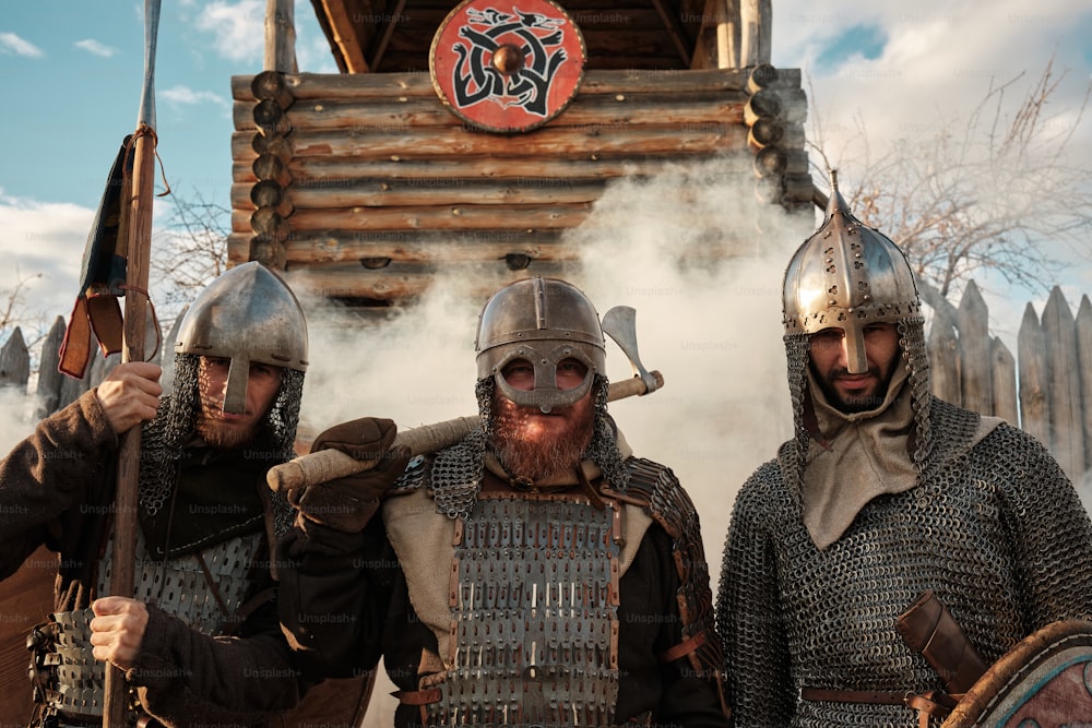 eine Gruppe von Männern in mittelalterlichen Rüstungen, die nebeneinander stehen