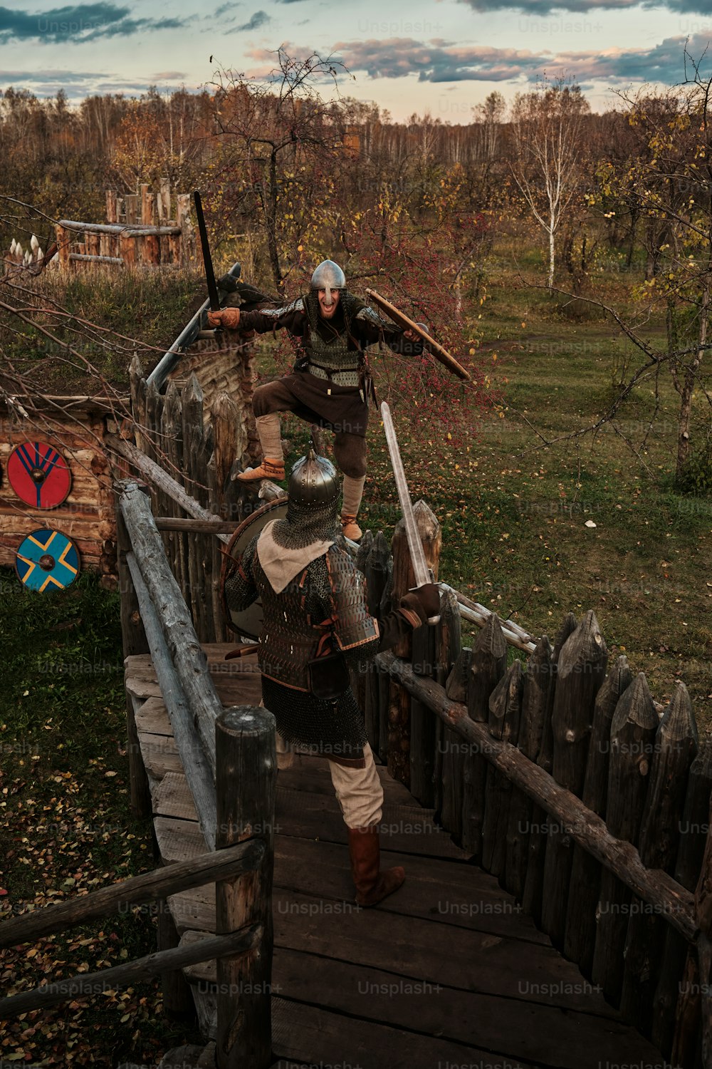 a man dressed in medieval clothing walking across a bridge