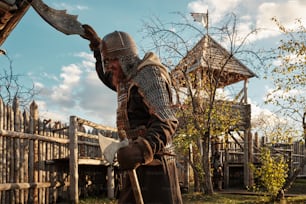 um homem vestido com roupas medievais segurando uma espada