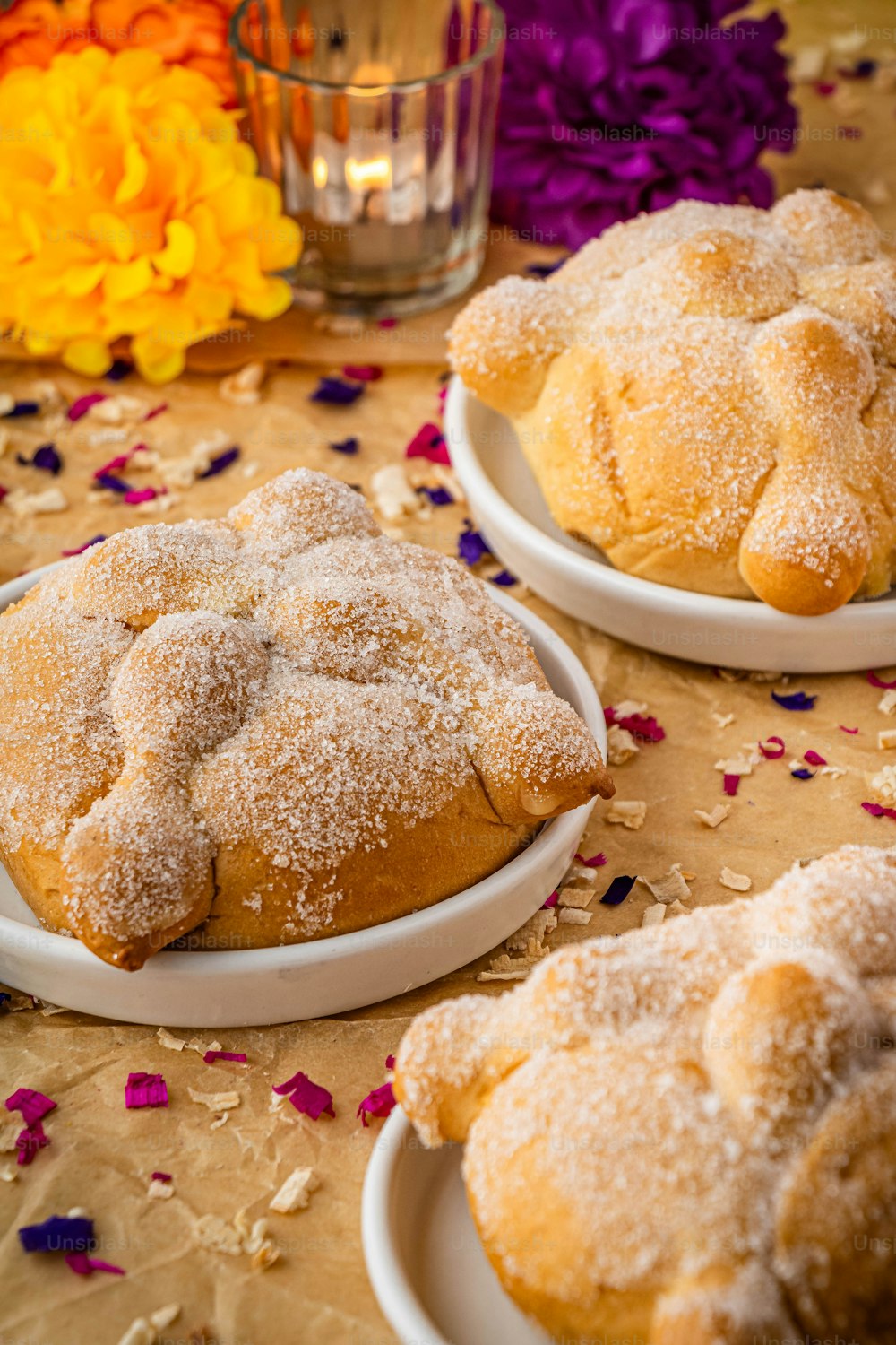 a table topped with plates of pastries covered in powdered sugar