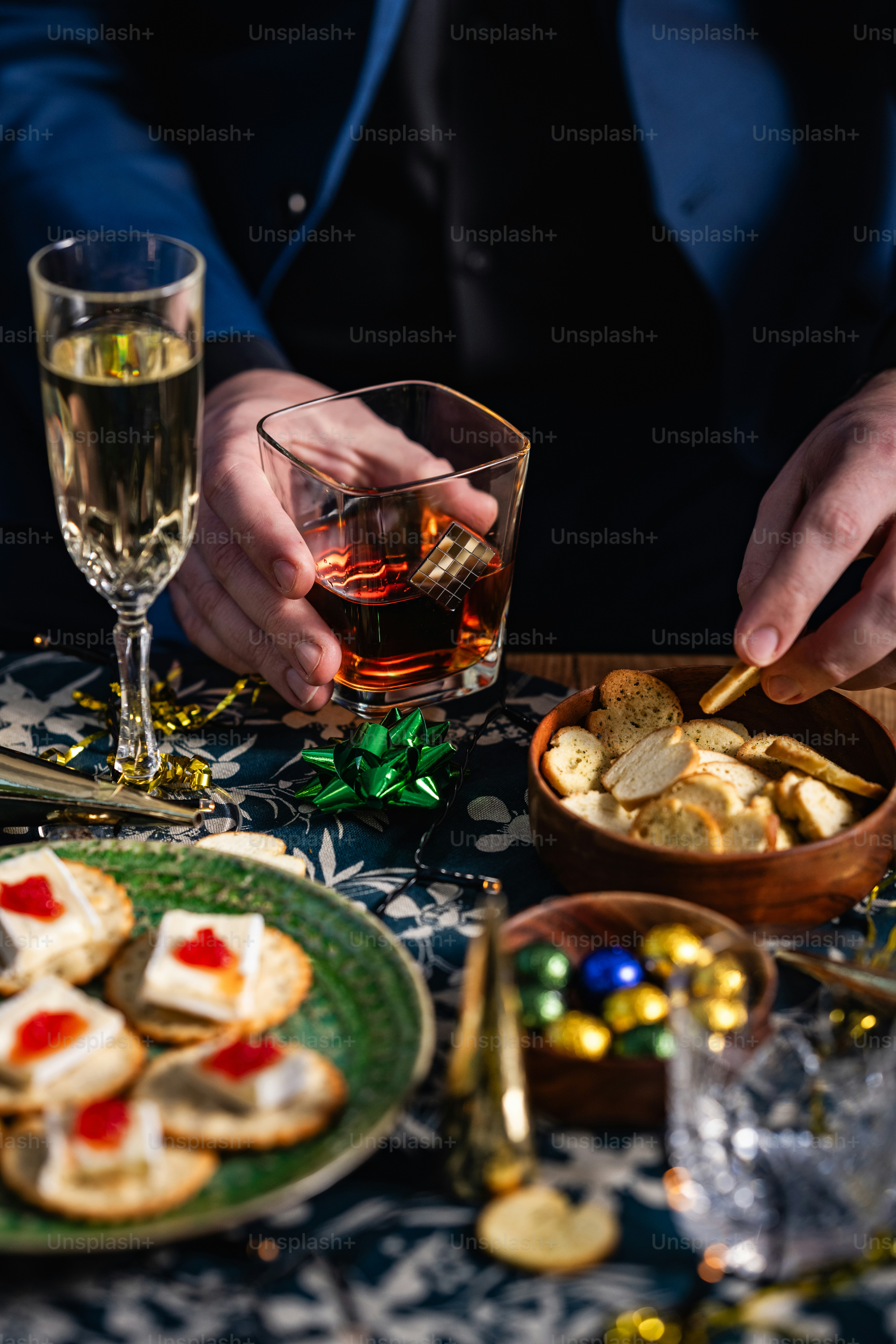 a man is sitting at a table with a plate of crackers and a glass