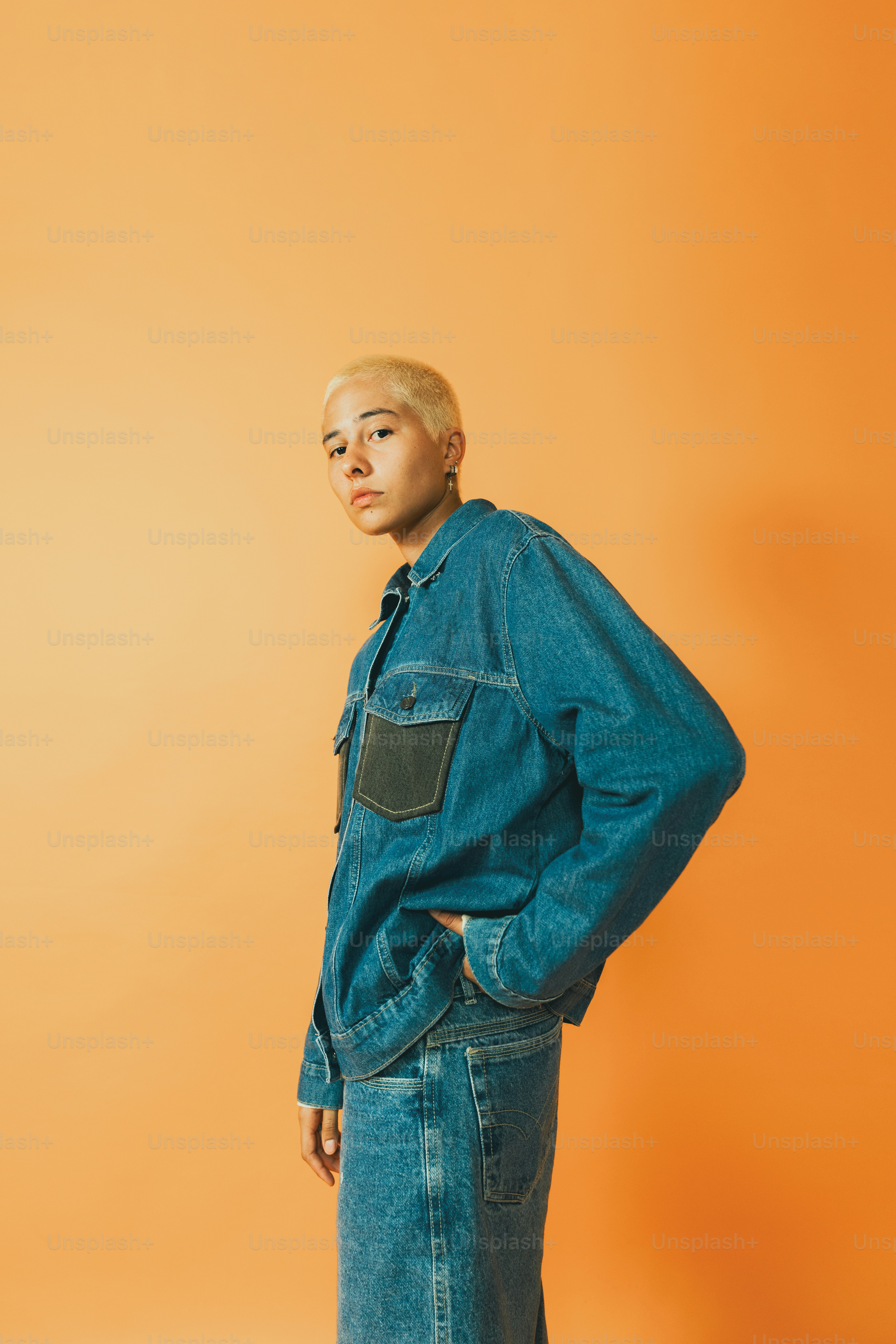 a man standing in front of an orange wall