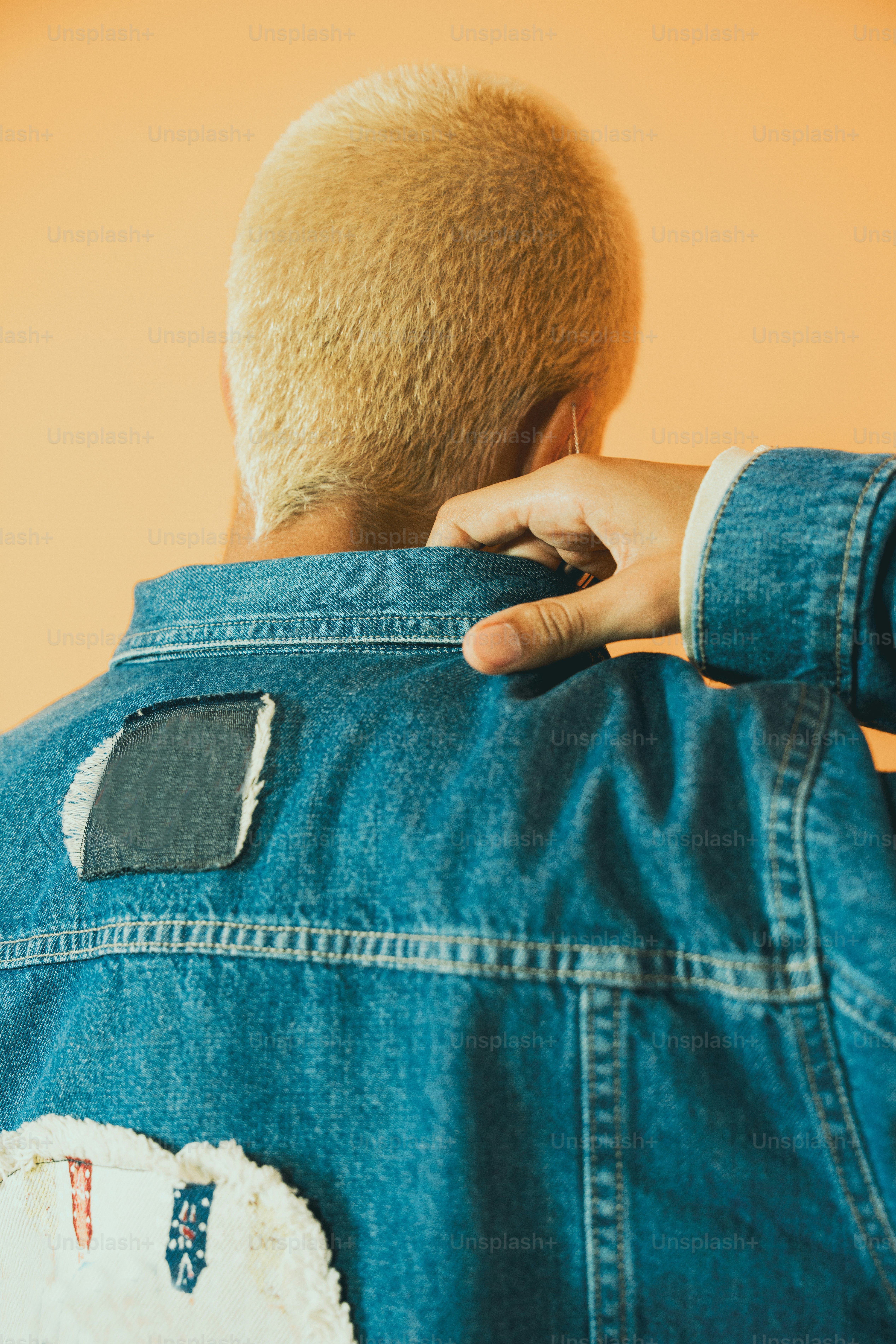a man in a jean jacket with a patch on the back of his jacket