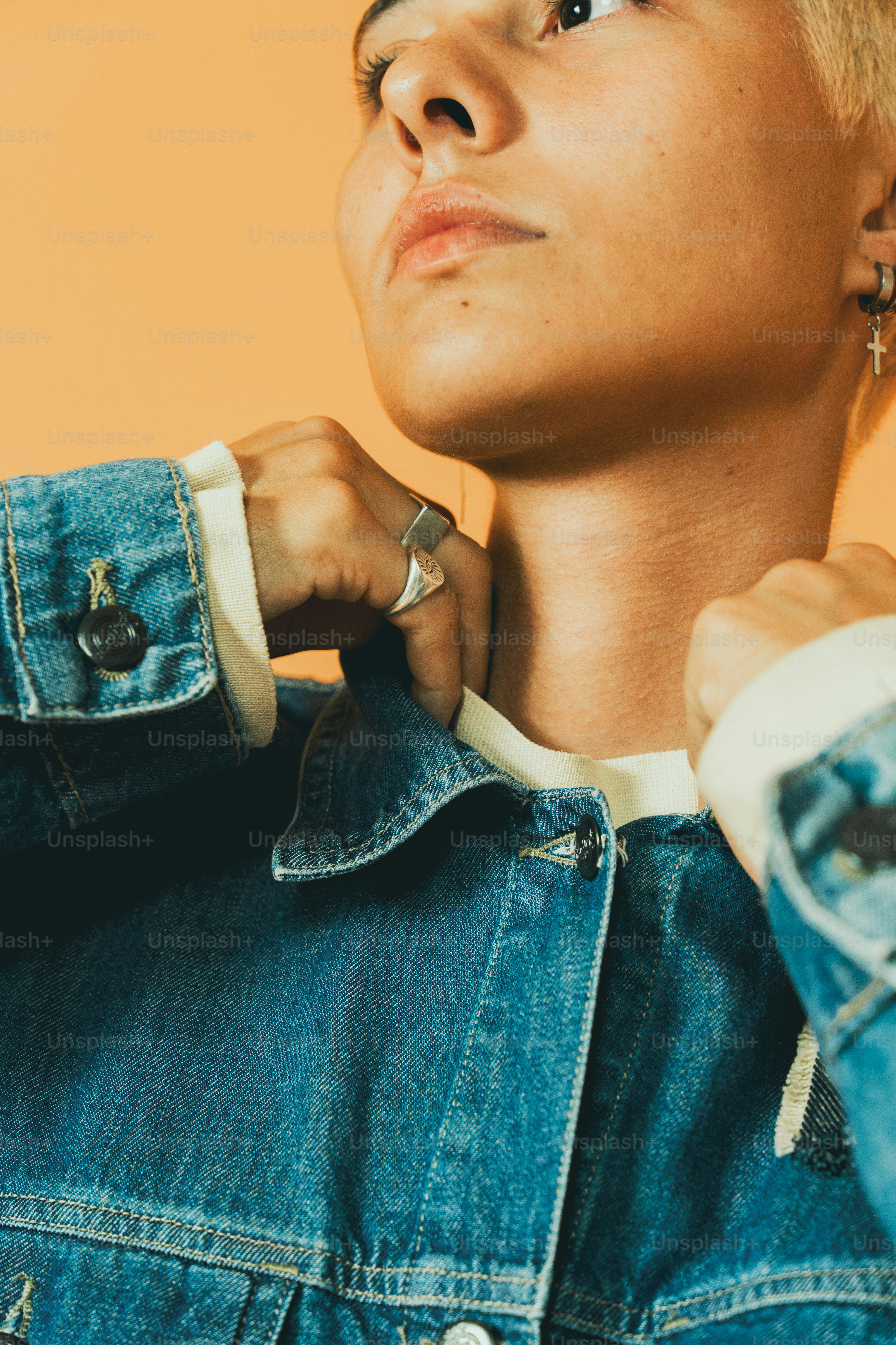uma mulher usando uma jaqueta jeans com um anel no dedo