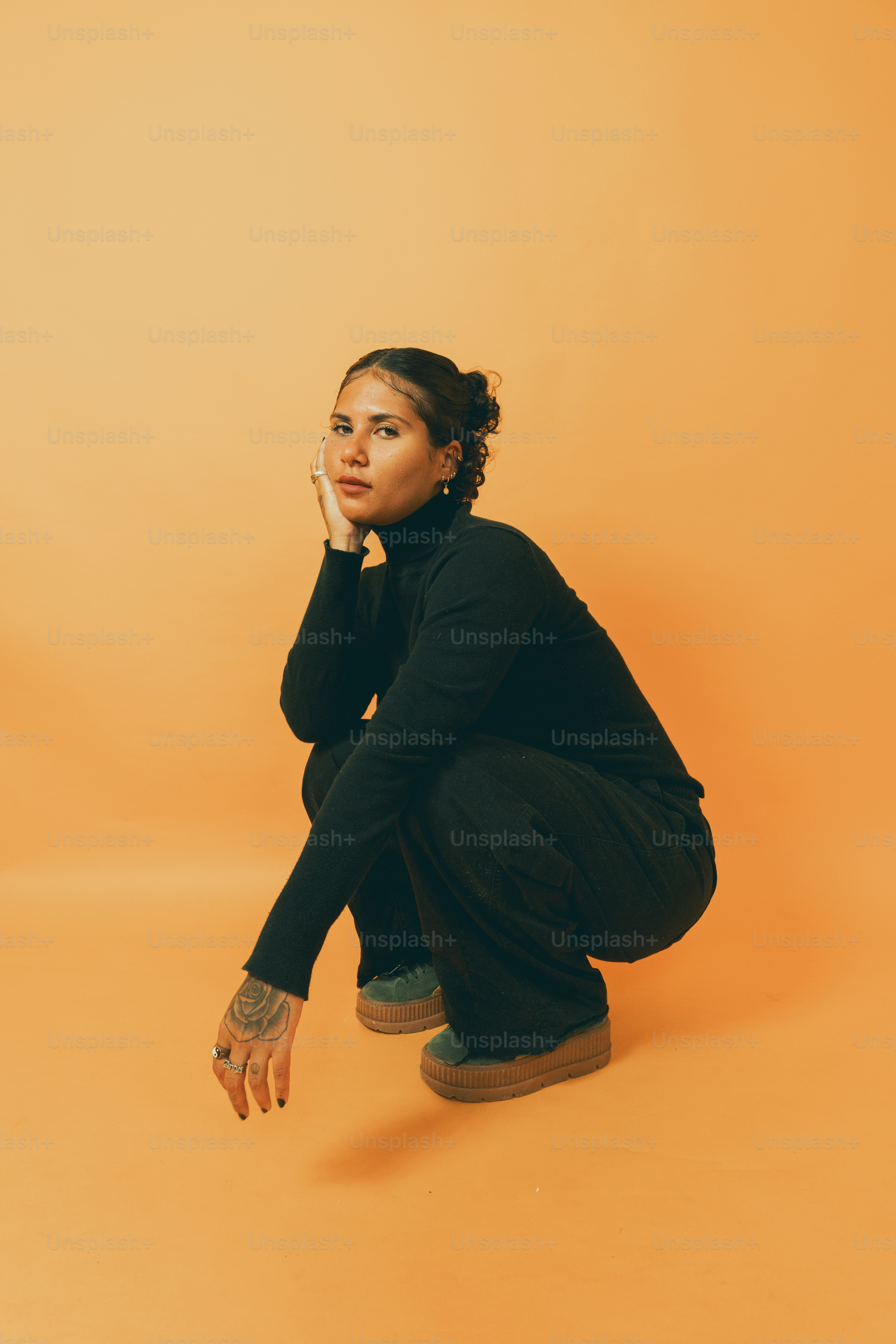a woman squatting on the ground with her hand on her face