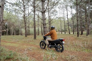 a man riding a motorcycle through a forest