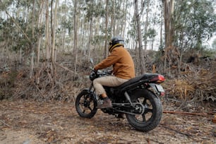 a man riding a motorcycle through a forest