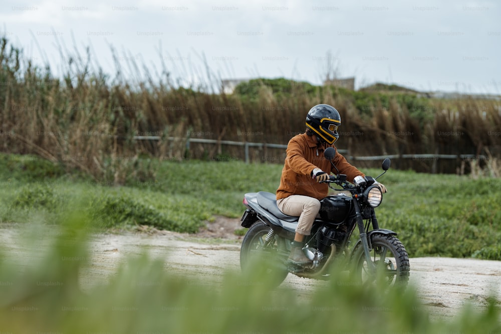 a man riding a motorcycle down a dirt road