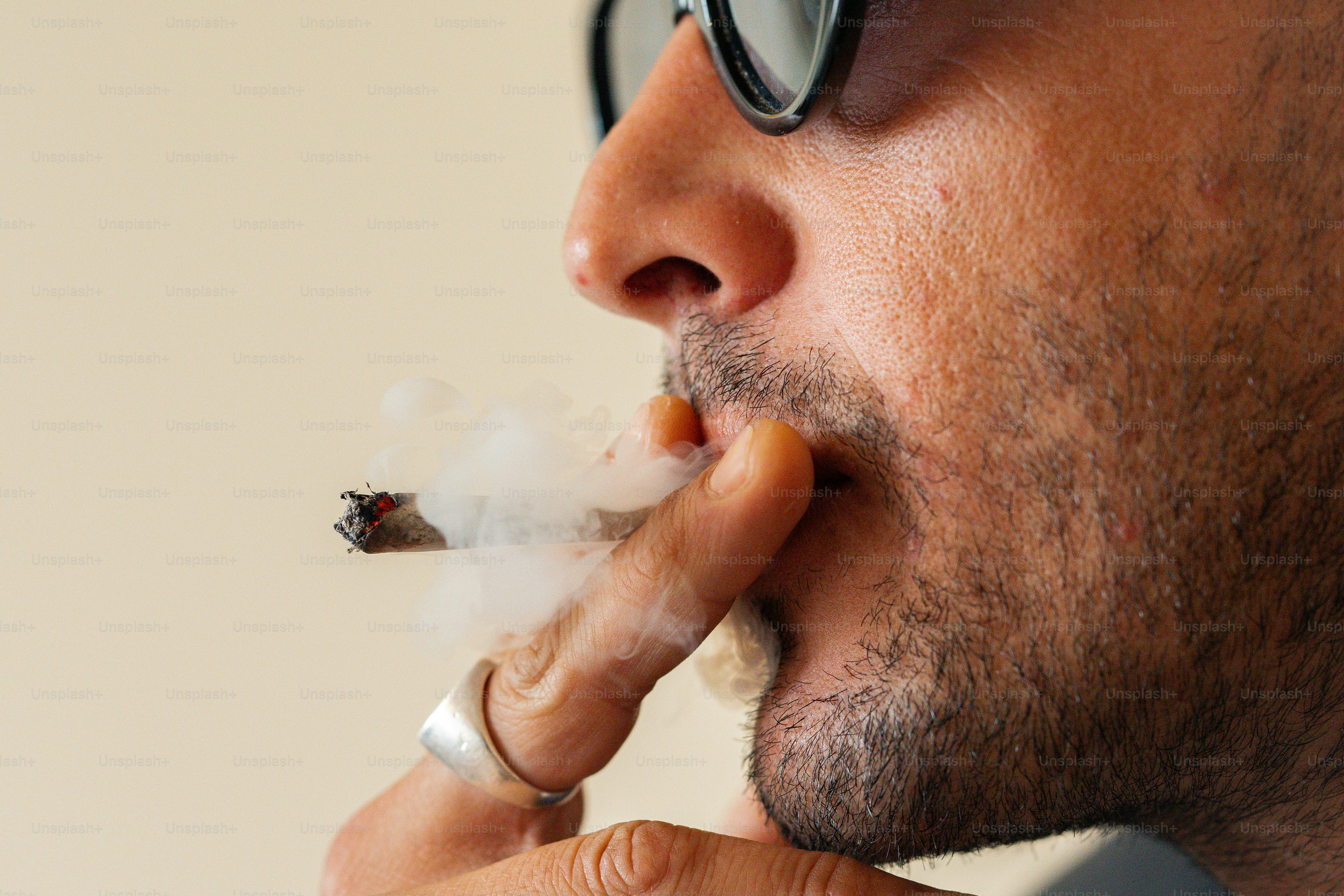 a man with glasses smoking a cigarette
