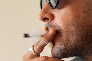 a man with glasses smoking a cigarette
