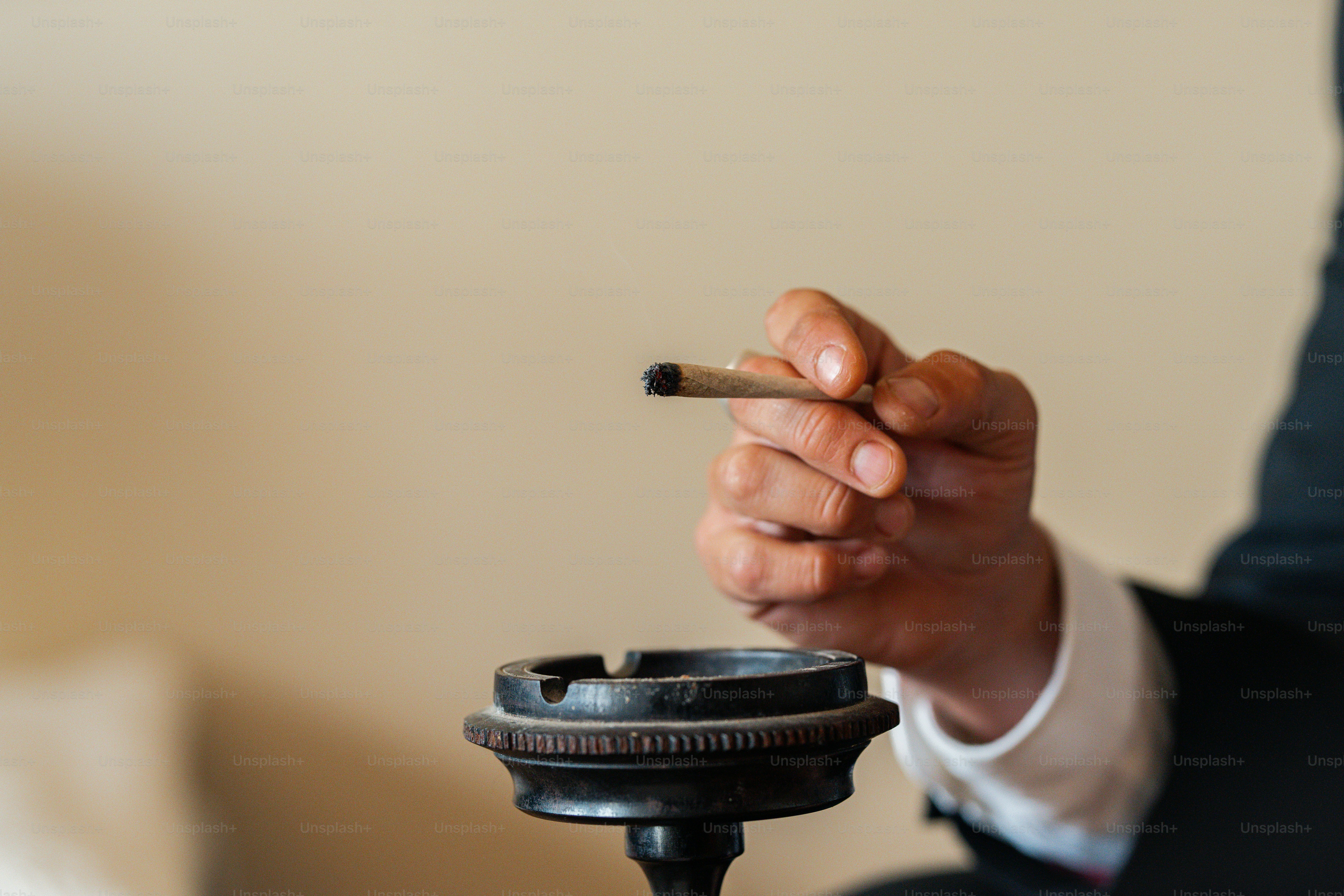 un uomo in giacca e cravatta che fuma una sigaretta