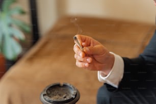 un homme en costume fumant une cigarette