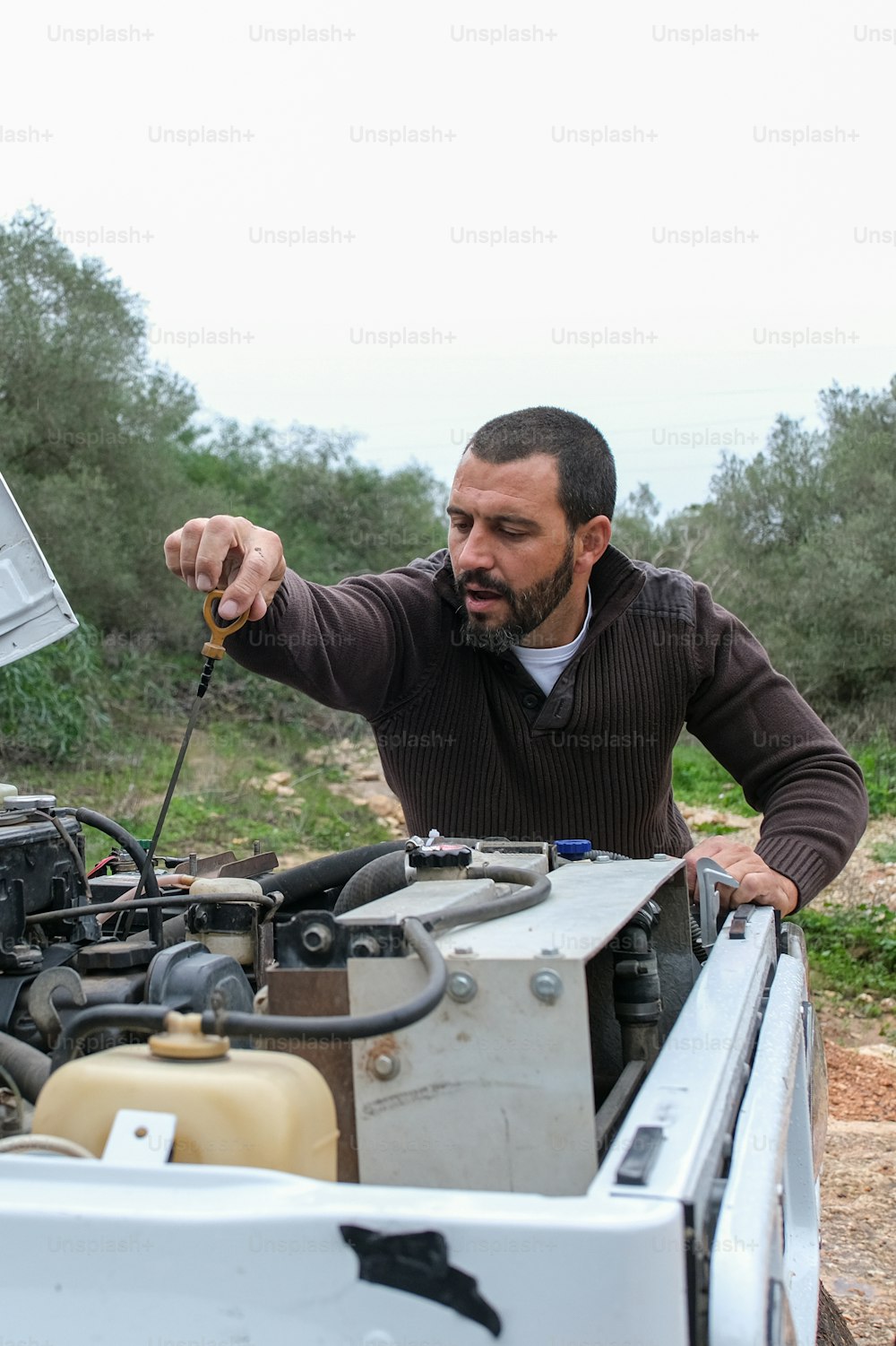 a man working on a car engine with a wrench