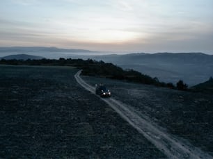 two people riding a motorcycle down a dirt road