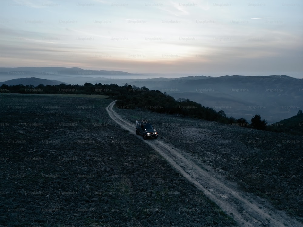 two people riding a motorcycle down a dirt road