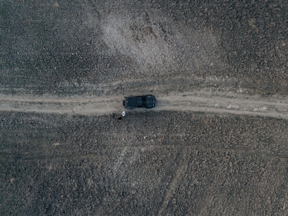 um caminhão dirigindo por uma estrada de terra no meio do nada