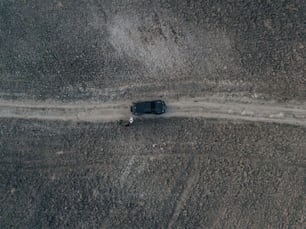 a truck driving down a dirt road in the middle of nowhere