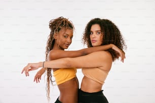 two women in sports bras hugging each other