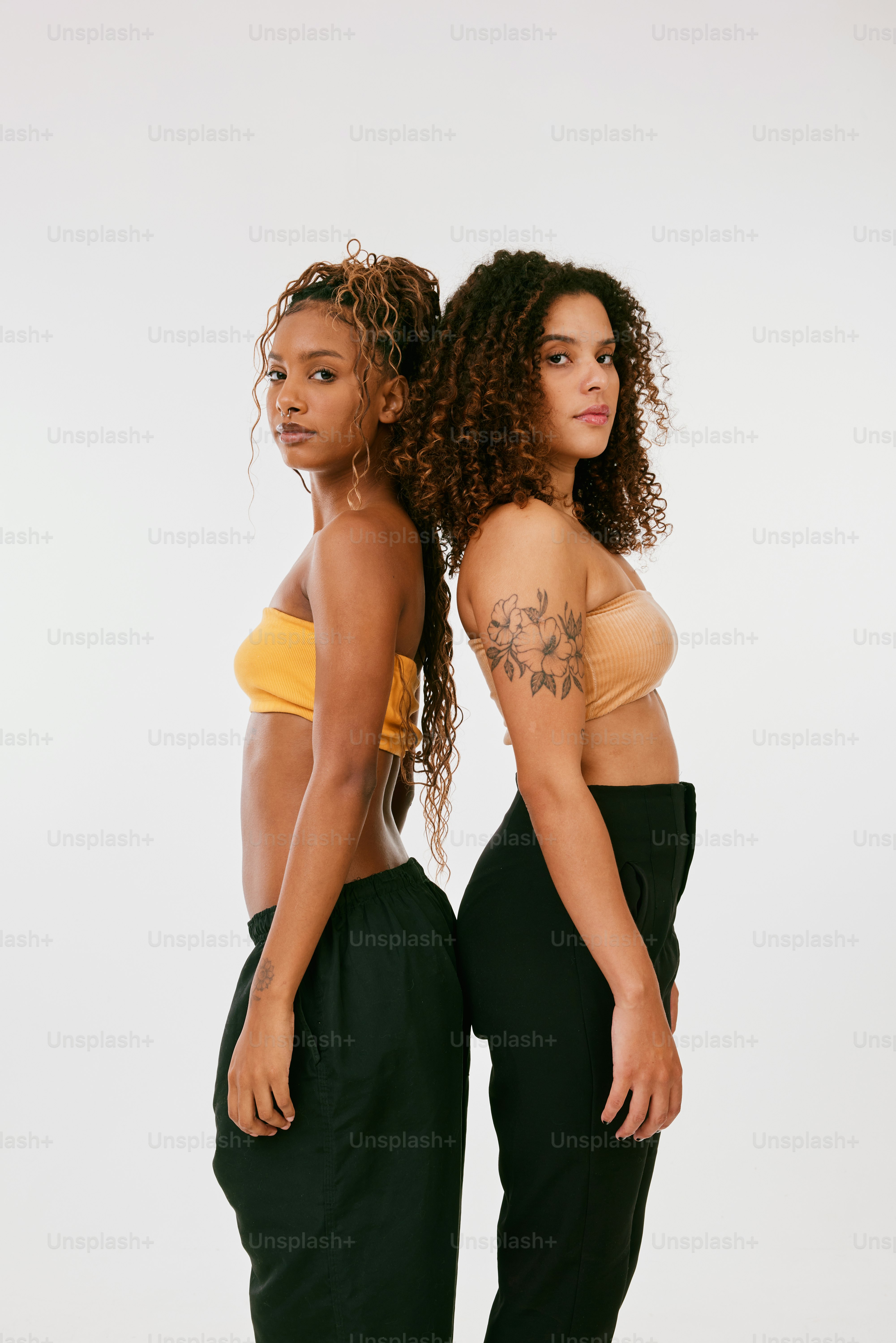 two women standing next to each other in matching outfits