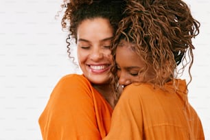 duas mulheres se abraçando e sorrindo