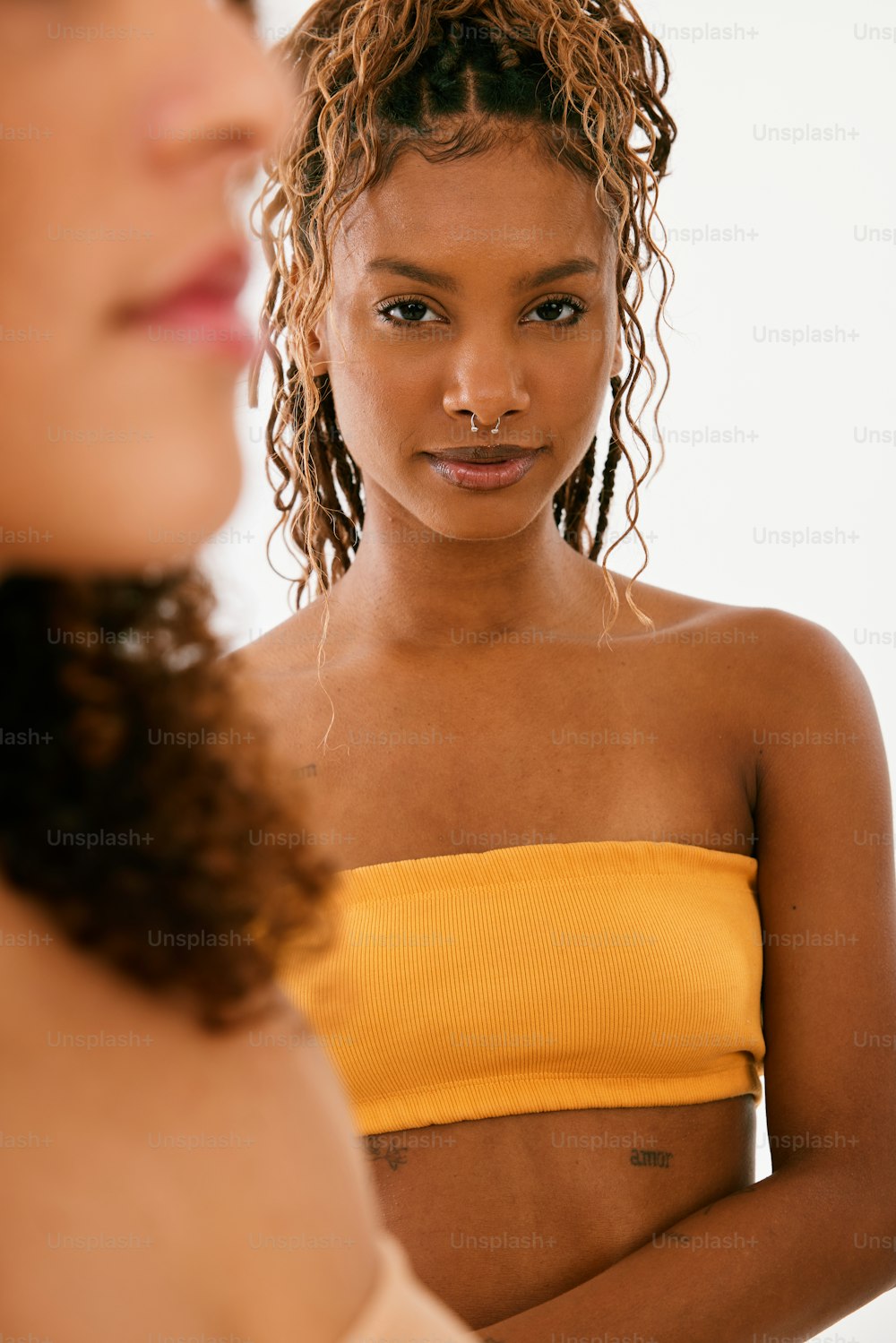 a woman in a yellow top looking in a mirror