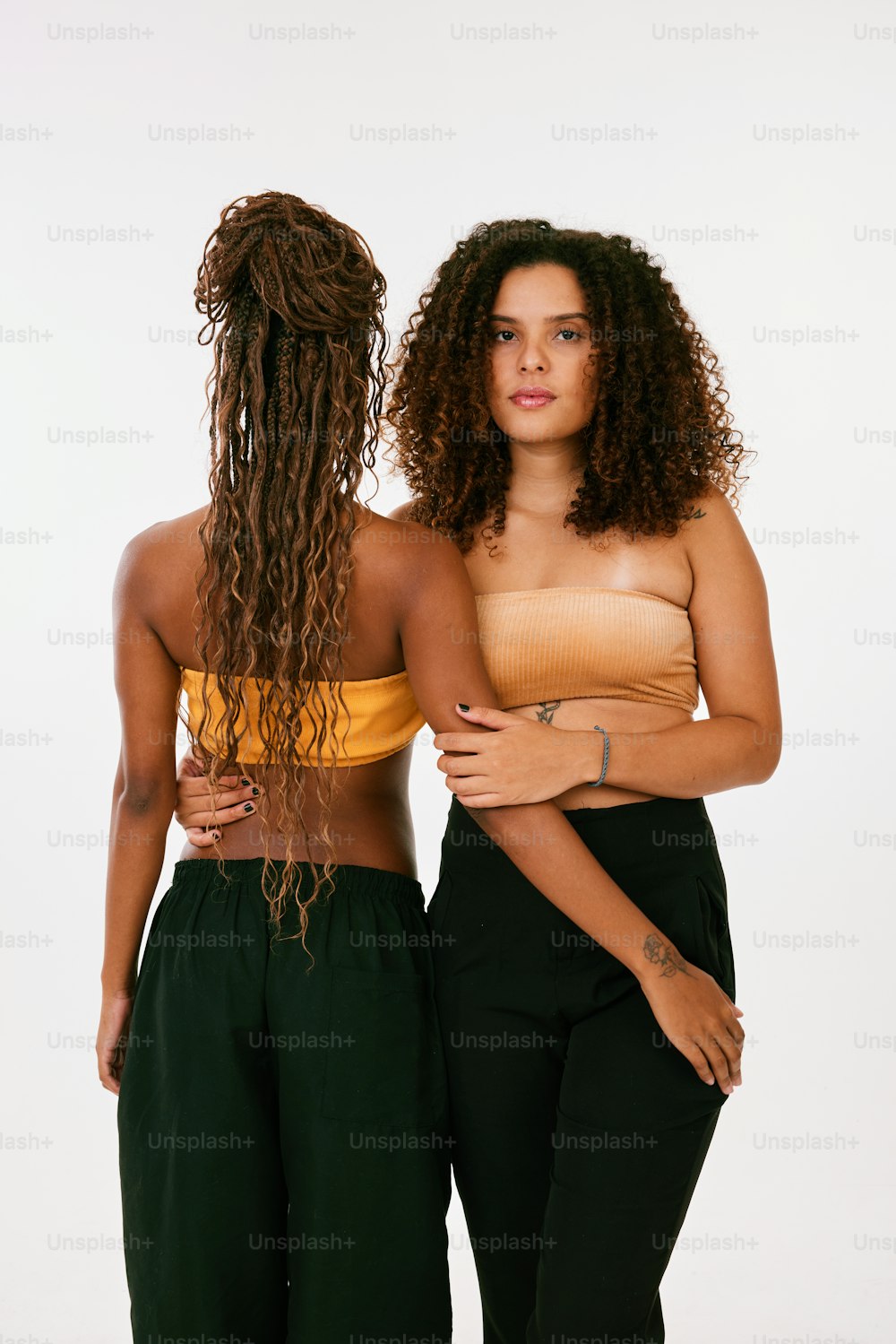 two women standing next to each other in front of a white background