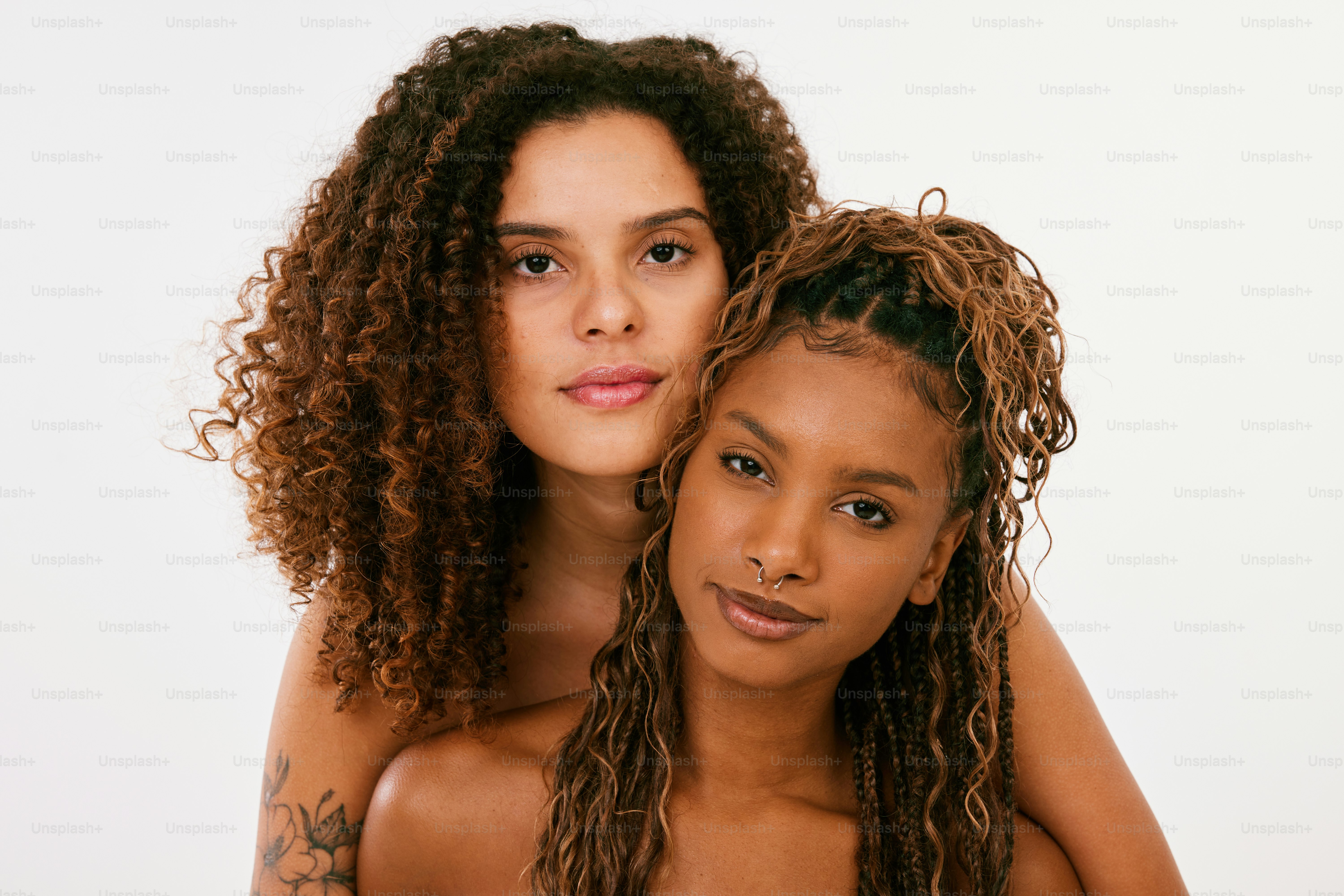 Two women with curly hair posing for a picture photo – Couple portrait ...