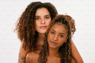 two women with curly hair posing for a picture