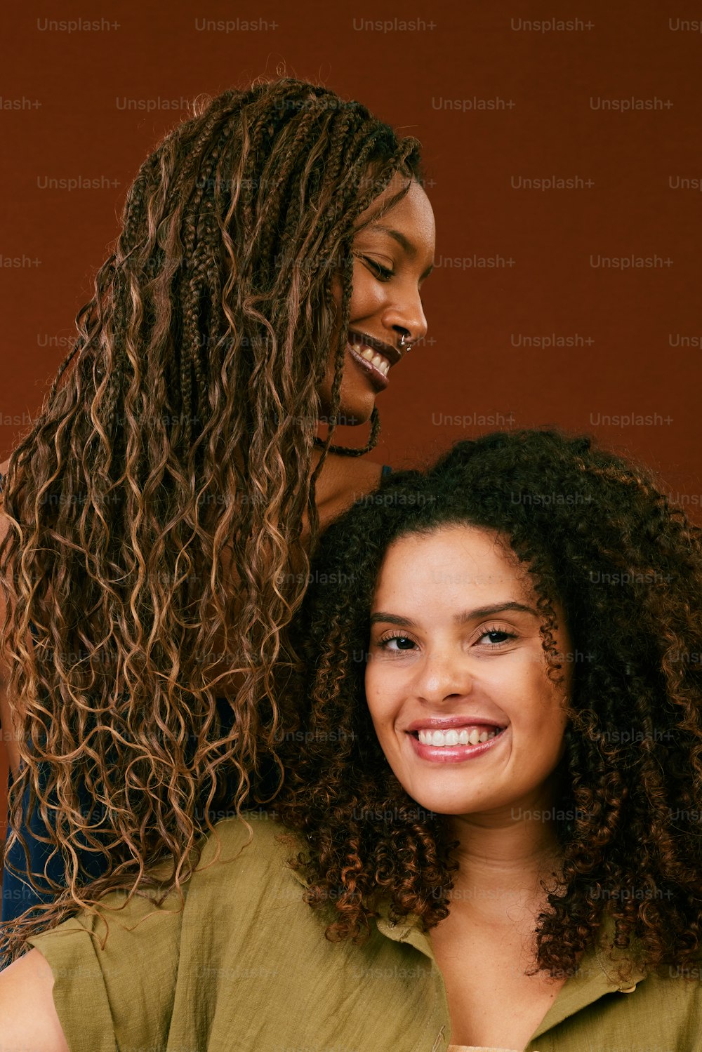 two women with curly hair standing next to each other