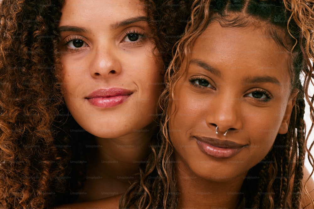 two beautiful women with curly hair and piercings