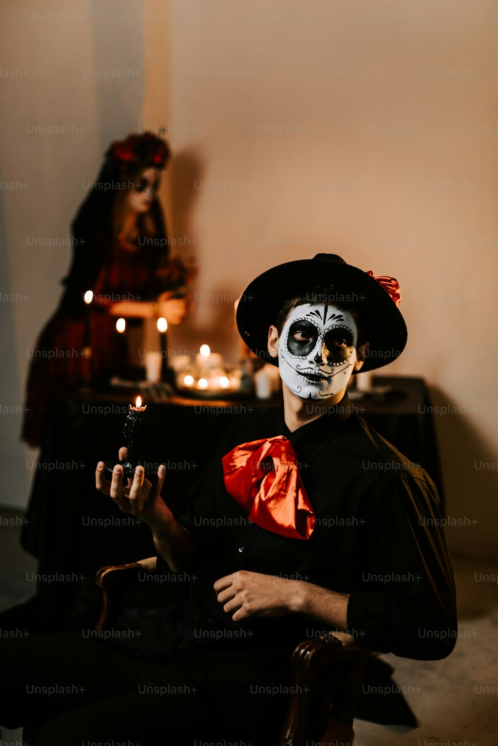 a man with a skeleton face paint sitting in a chair