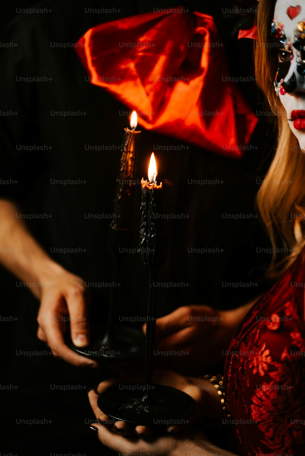 a woman in a mask holding a candle