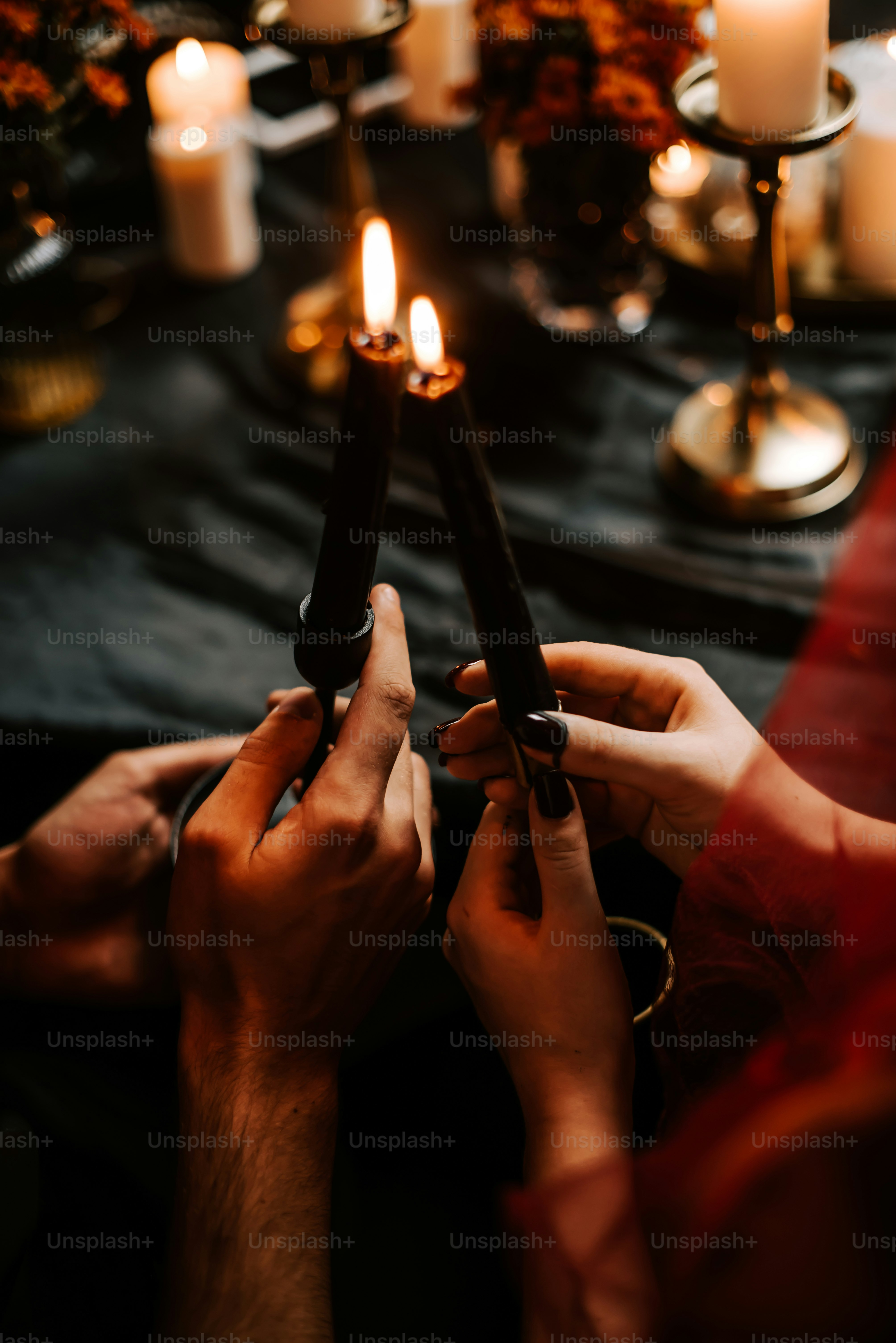 um casal de pessoas sentadas em uma mesa com velas