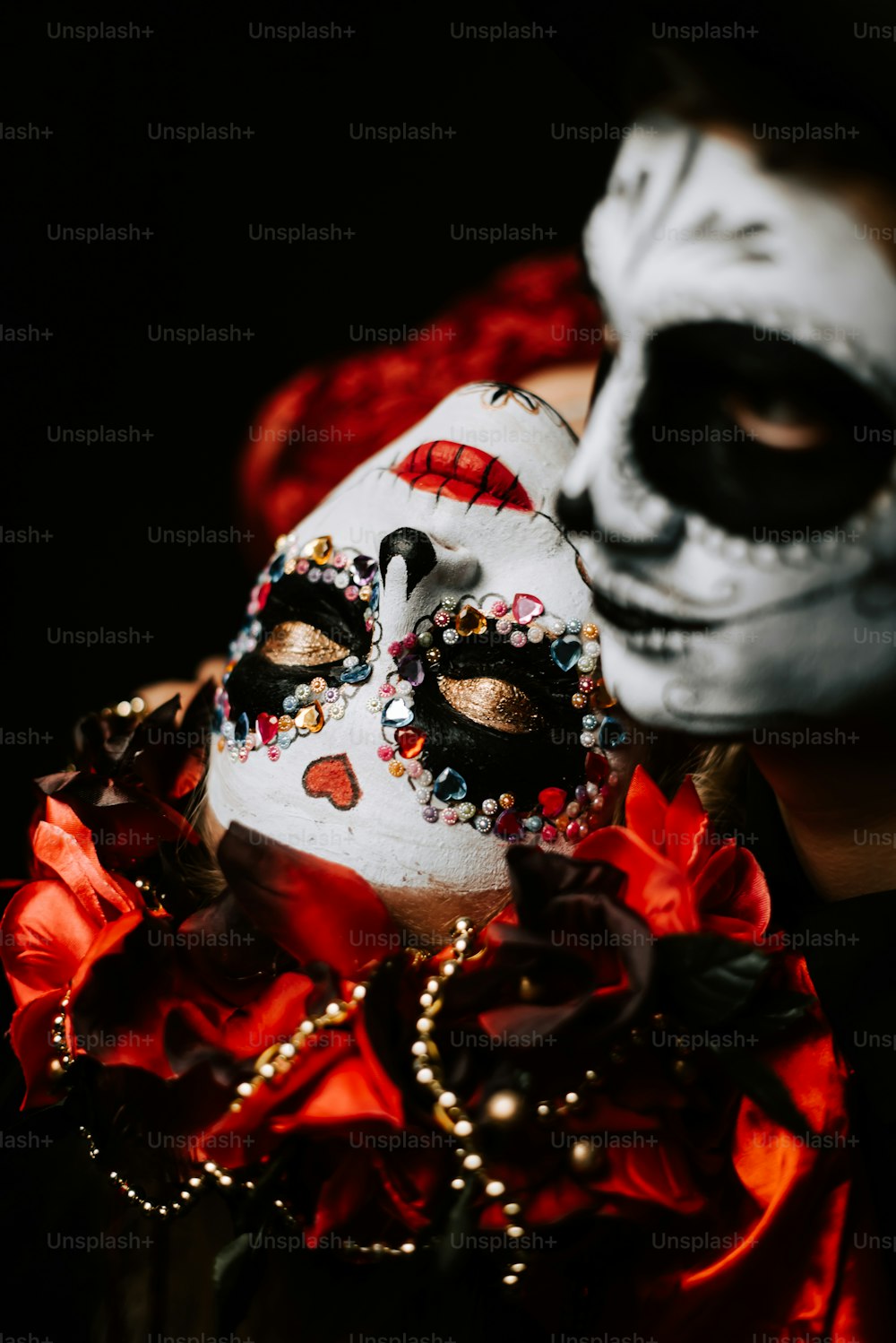 eine Person, die eine weiße Maske mit roten Blumen trägt