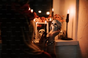 a woman holding a skull mask in front of a mirror