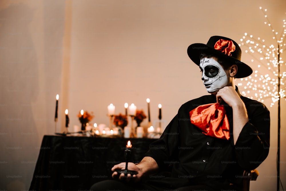 a man with a skeleton face paint sitting in a chair