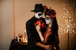 un hombre y una mujer vestidos con maquillaje de esqueleto