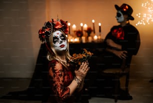 une femme dans un masque de squelette tenant des fleurs