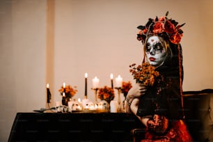 une femme dans un masque de squelette tenant un bouquet de fleurs