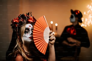 a woman in a skeleton makeup holding a fan