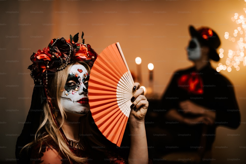 a woman in a skeleton makeup holding a fan