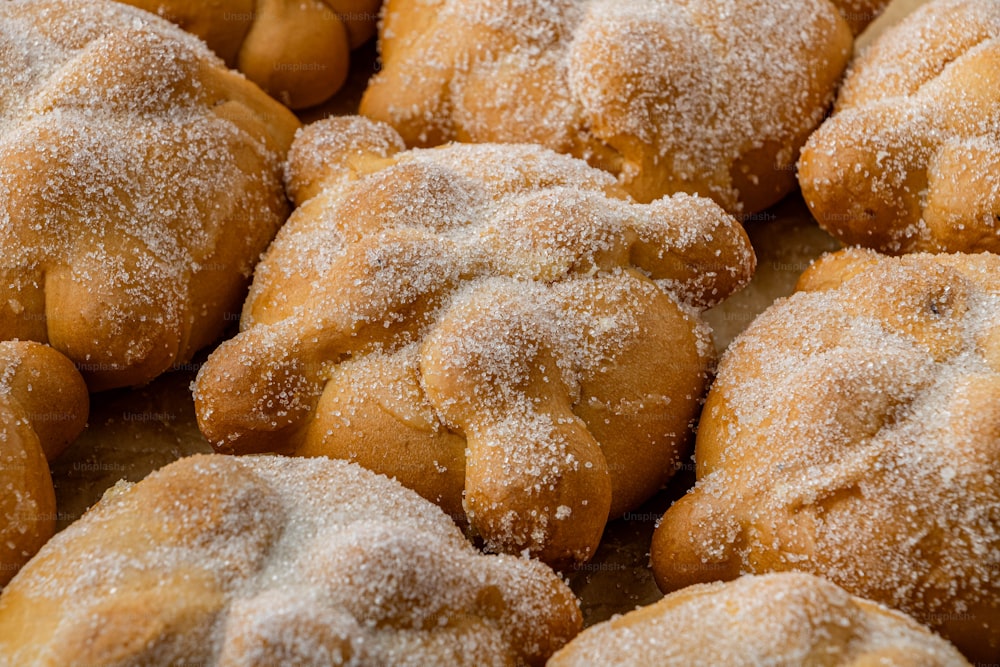 a close up of a bunch of doughnuts covered in powdered sugar