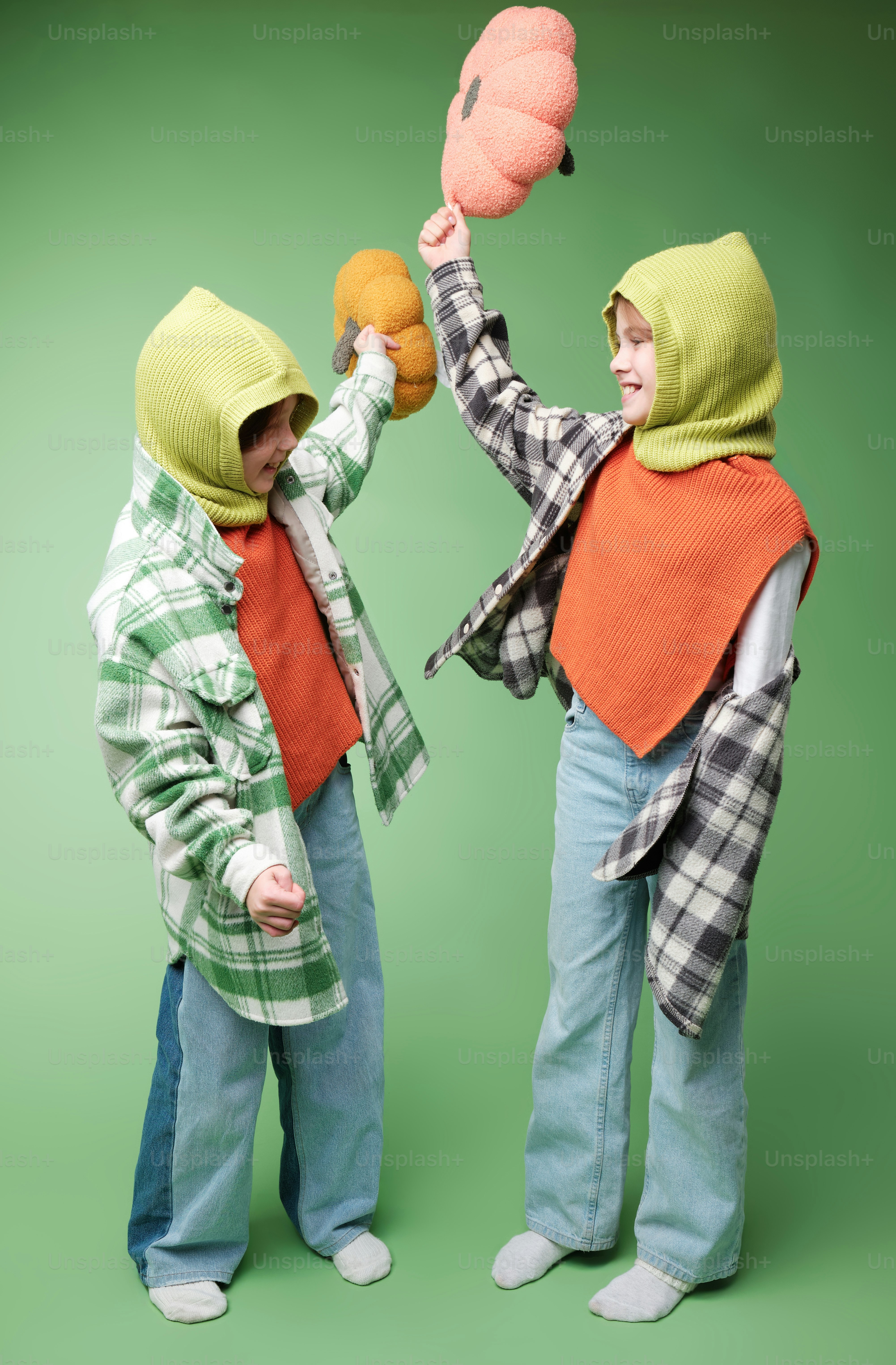 A two girls in autumn clothes on studio background in warm color scheme