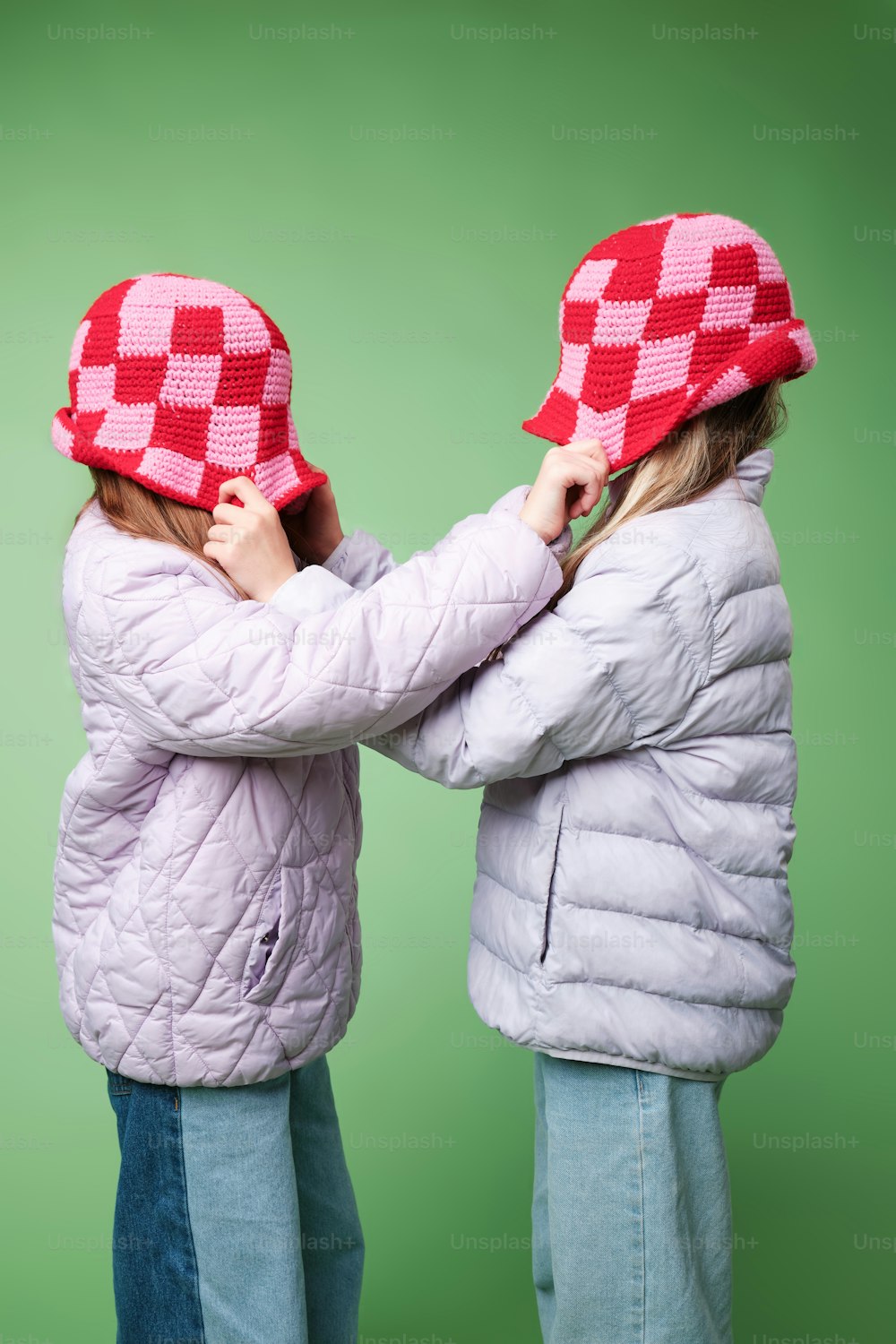 two little girls wearing matching hats on their heads