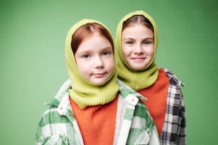 two young girls wearing knitted hoods and scarves