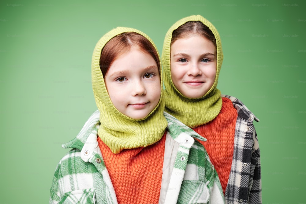 ニットのフードとスカーフを身に着けた2人の少女