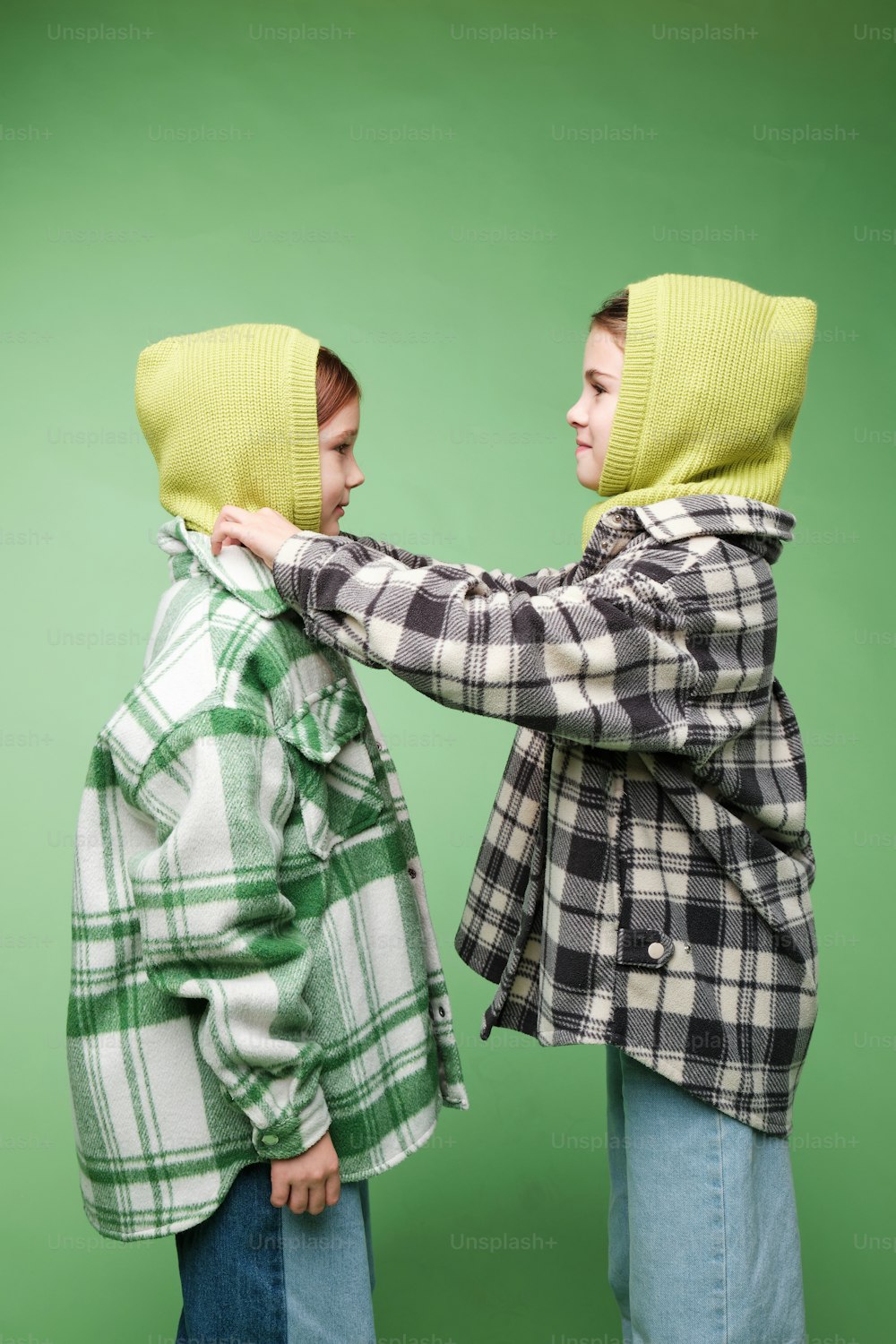 two young boys wearing hooded jackets and scarves