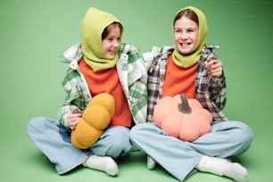 two young girls sitting on the floor with stuffed animals
