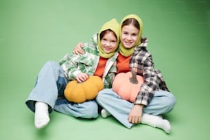 two children sitting on the ground with stuffed animals